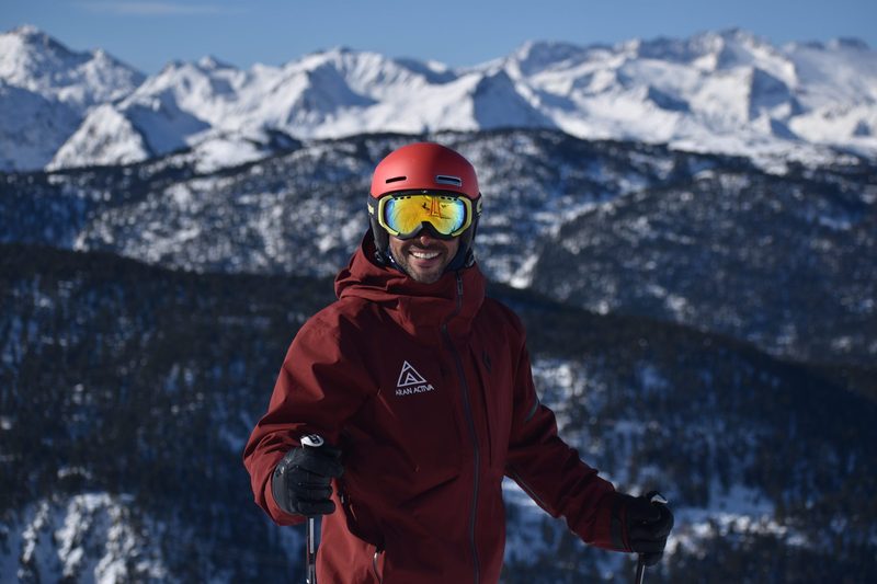 Instructor de Aran Days sonriendo con las montañas nevadas de Baqueira Beret al fondo