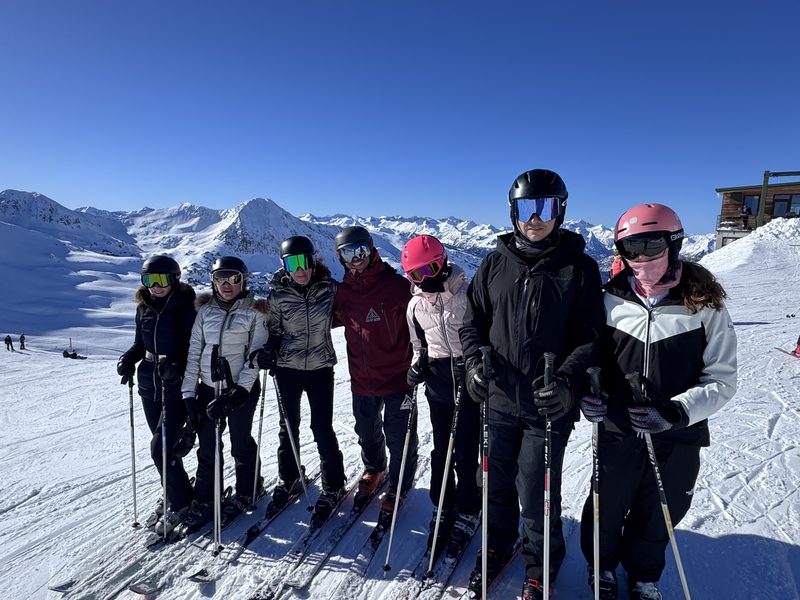 Grupo de esquiadores posando con los esquís puestos en la pista de Baqueira Beret