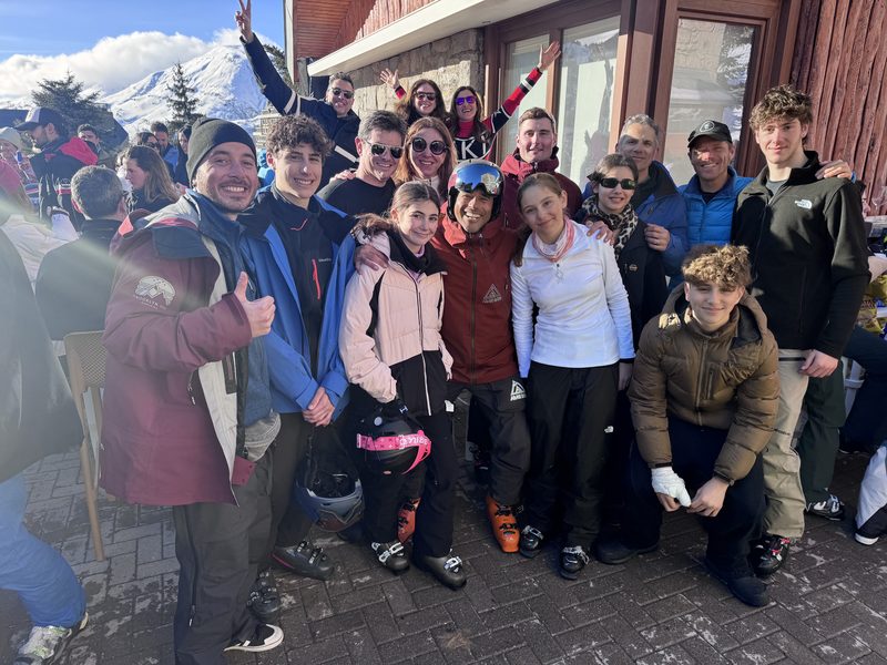 Grupo grande de familias y amigos posando juntos tras una jornada de esquí