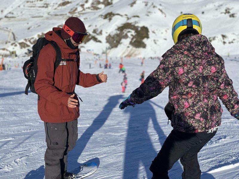 Instructor de Aran Days explicando a una alumna durante una clase de snowboard