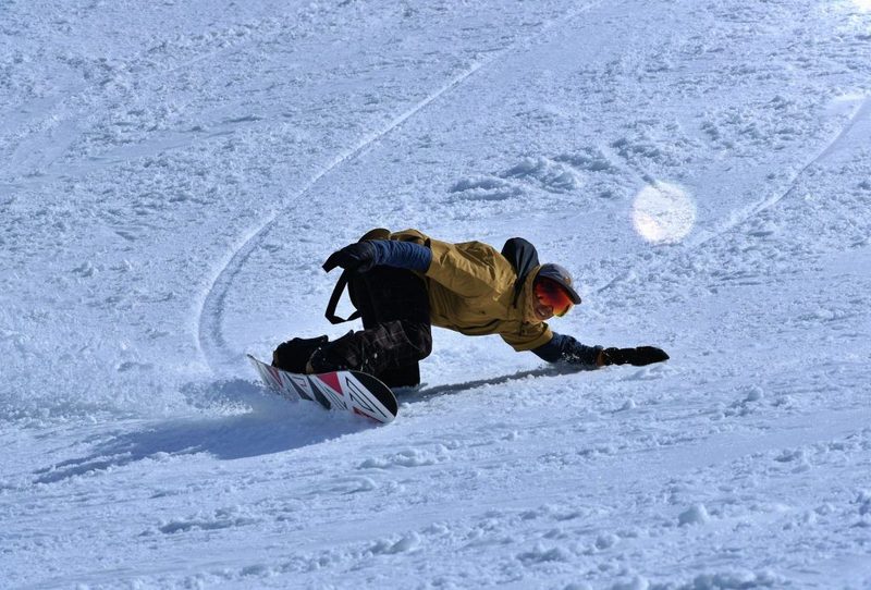 Snowboarder tumbando una curva sobre la nieve de Baqueira Beret