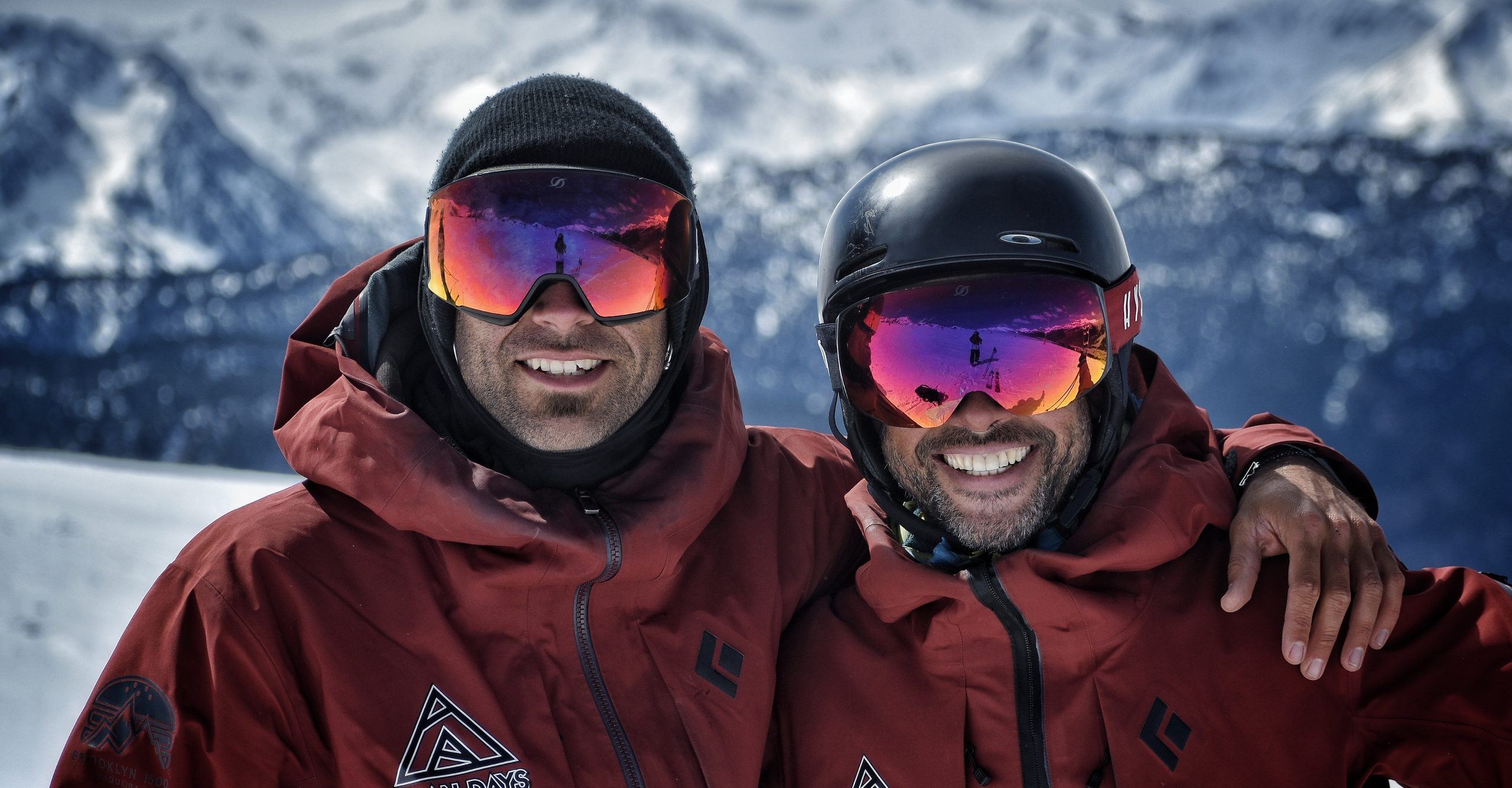 Dos instructores de Aran Days sonriendo a cámara con las montañas nevadas al fondo