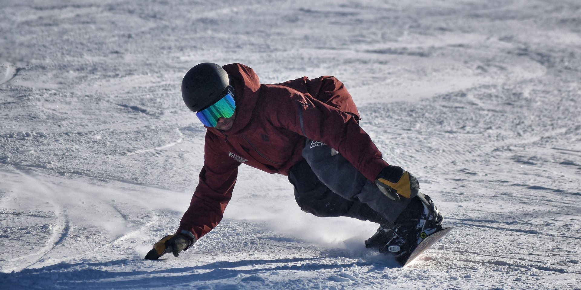 Instructor de Aran Days trazando un giro con snowboard sobre la nieve de Baqueira Beret